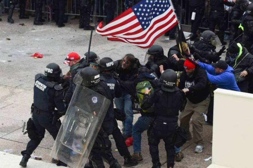 Trump supporters clash with police and security forces as they storm the US Capitol in Washington D.C on January 6, 2021. - Demonstrators breeched security and entered the Capitol as Congress debated the a 2020 presidential election Electoral Vote Certification. (Photo by ROBERTO SCHMIDT / AFP)