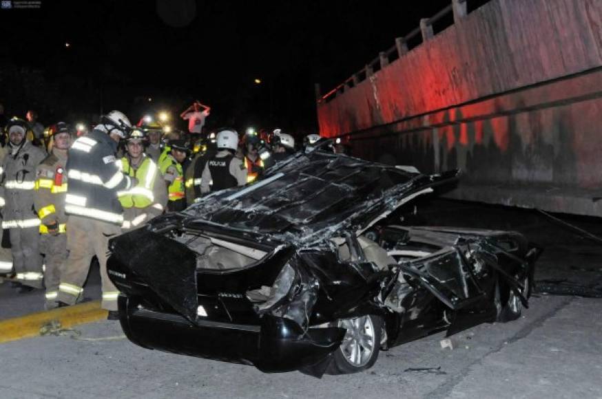 Los equipos de rescate están delante de un coche destruido tras el colapso de un puente en Guayaquil.