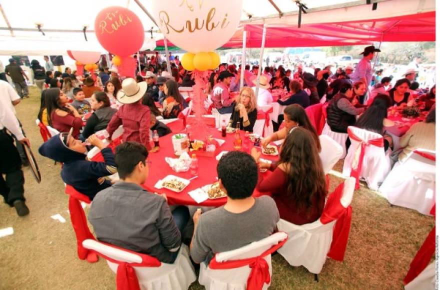 Las mesas decoradas con manteles rojos y globos con el nombre de Rubí.
