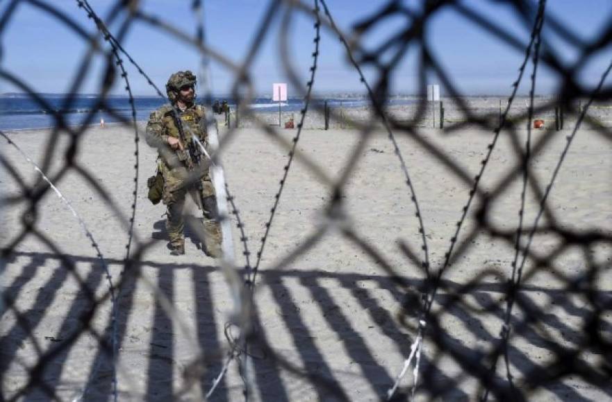A US police agent stands guard near the U.S.-Mexico border fence as seen from Playas de Tijuana, Mexico, on November 15, 2018. - US Defence Secretary Jim Mattis said Tuesday he will visit the US-Mexico border, where thousands of active-duty soldiers have been deployed to help border police prepare for the arrival of a 'caravan' of migrants. (Photo by ALFREDO ESTRELLA / AFP)