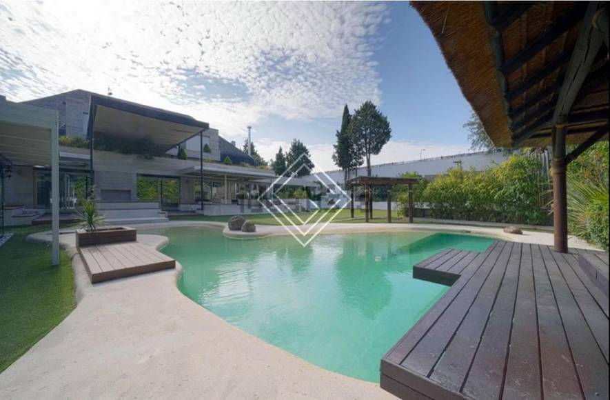 En el exterior de la enorme casa se puede disfrutar de una piscina con porche.