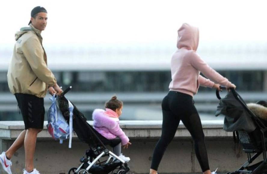 Cristiano Ronaldo (L) and his partner Georgina Rodriguez push two strollers as they have a walk with their children in Funchal on March 28, 2020. (Photo by HELDER SANTOS / AFP)