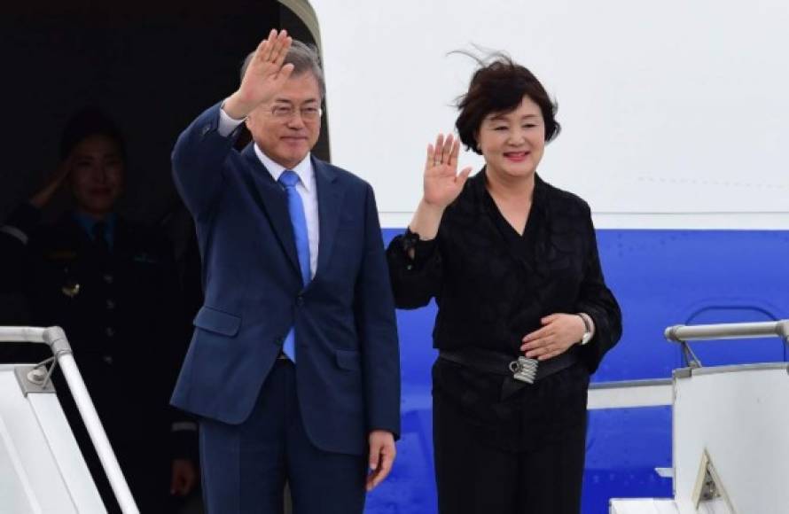 El presidente de Corea del Sur, Moon Jae-in, y su esposa Kim Jung-sook, saludan al llegar al aeropuerto internacional de Ezeiza en la provincia de Buenos Aires.
