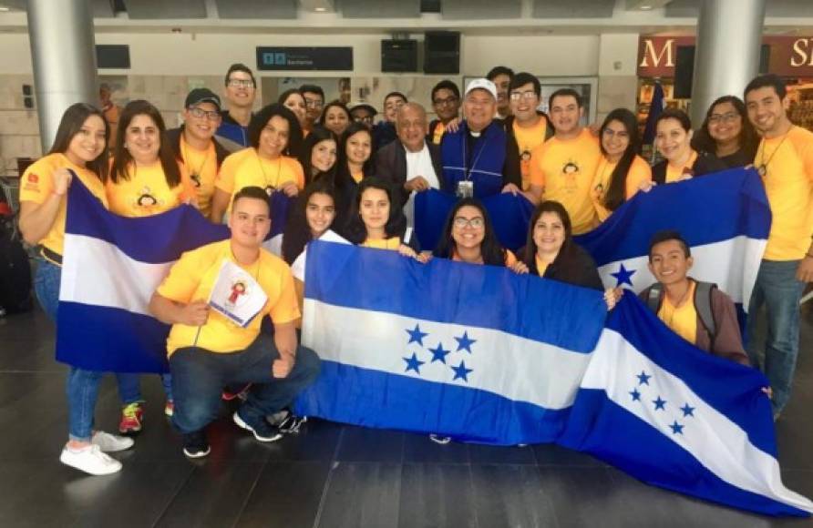 Los catrachos posan con la bandera de Honduras en compañía del obispo José Antonio Canales.
