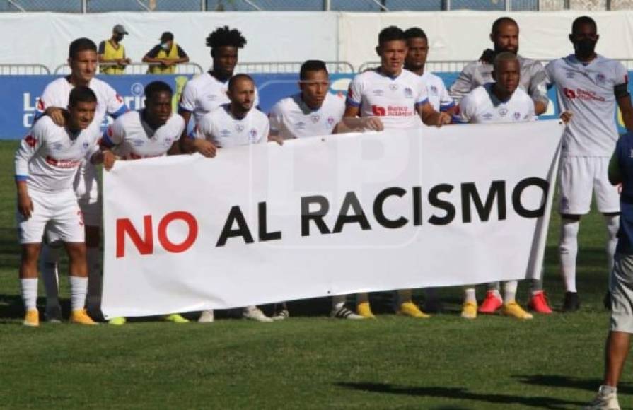 Previo al inicio del partido, la plantilla del Olimpia posó con esta pancarta en la que piden un alto al racismo.