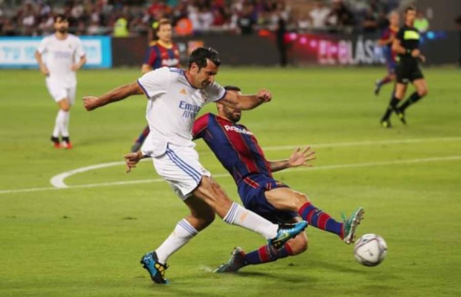 Luis Figo mandando un centro ante la marca de un defensa culé.