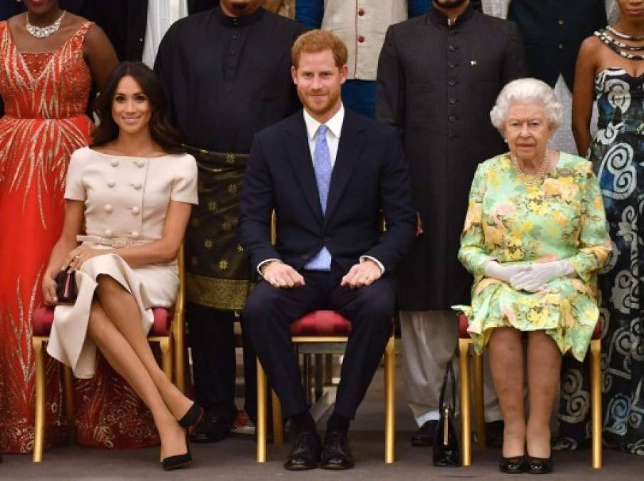 (FILES) In this file photo taken on June 26, 2018 (L-R) Meghan, Duchess of Sussex, Britain's Prince Harry, Duke of Sussex and Britain's Queen Elizabeth II pose for a picture during the Queen's Young Leaders Awards Ceremony at Buckingham Palace in London. - Britain's royal family on Sunday braced for further revelations from Prince Harry and his American wife, Meghan, as a week of transatlantic claim and counter-claim reaches a climax with the broadcast of their interview with Oprah Winfrey. (Photo by John Stillwell / AFP)