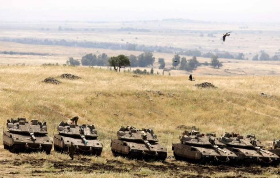 Israeli Merkava tanks are seen in a deployment area near the Syrian border in the Israel-annexed Golan Heights on May 10, 2018.<br/>Israel's army said today it had carried out widespread raids against Iranian targets in Syria overnight after rocket fire towards its forces it blamed on Iran, marking a sharp escalation between the two enemies. Israel carried out the raids after it said around 20 rockets, either Fajr or Grad type, were fired from Syria at its forces in the occupied Golan Heights at around midnight. / AFP PHOTO / MENAHEM KAHANA