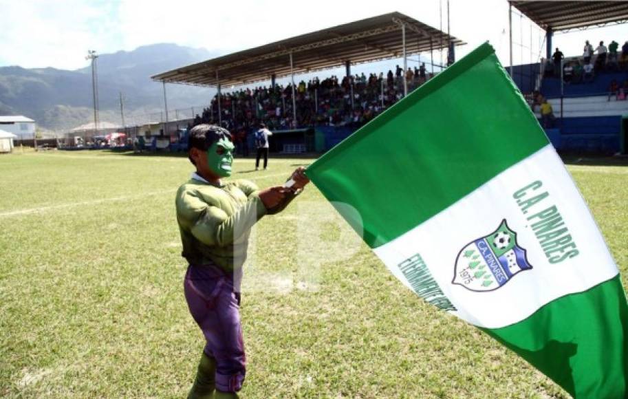 Un pequeño aficionado, con un traje de Hulk, ondeando una bandera del Atlético Pinares.