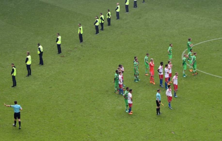 Jugadores del Hamburgo fueron resguardos por agentes de seguridad tras el descenso y los disturbios de los aficionados.