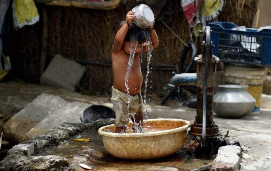 Pequeños y grandes buscan refrescarse debido a las altas temperaturas que afectan el sur de la India.