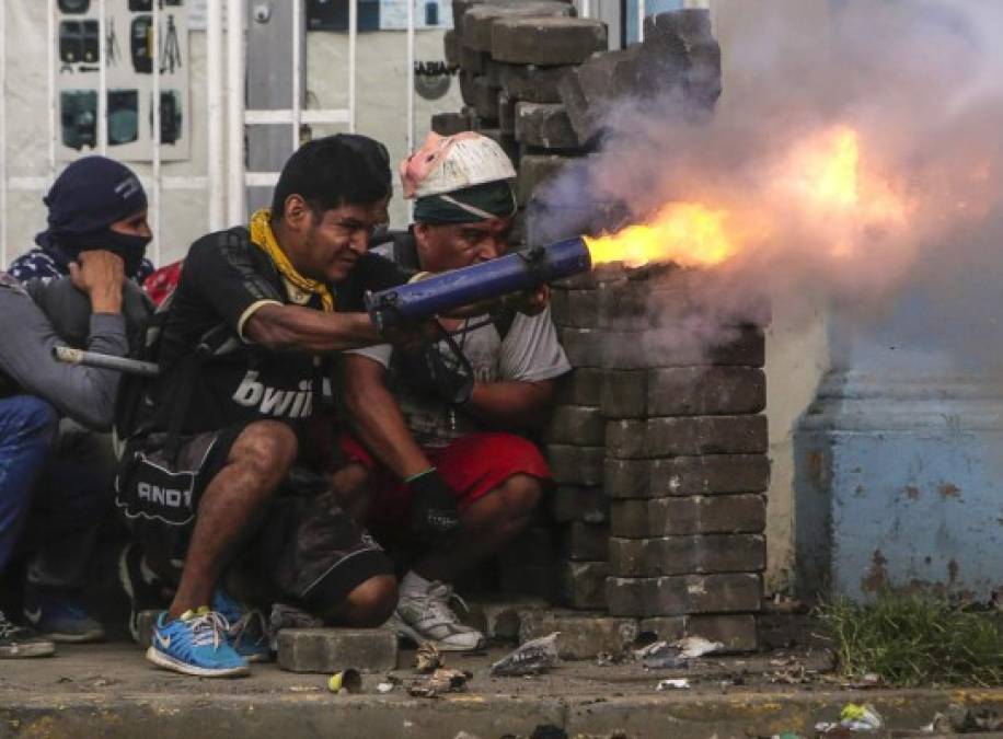 TOPSHOT - An anti-government demonstrator fires a home-made mortar during clashes with riot police at a barricade in the town of Masaya, 35 km from Managua on June 9, 2018. / AFP PHOTO / INTI OCON