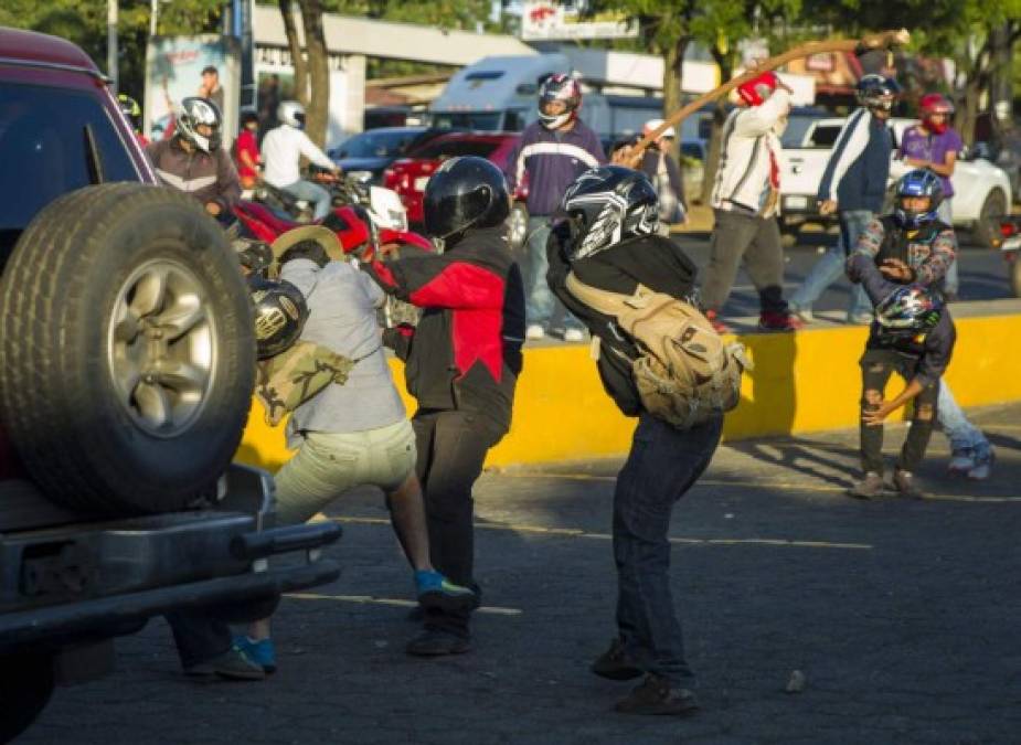 Dos miembros de las fuerzas antichoque agreden a una persona durante las protestas en contra de las reformas del Instituto Nicaragüense de Seguridad Social (INSS), en Managua (Nicaragua).