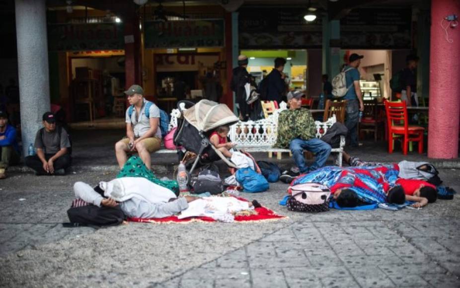 Los migrantes, en su mayoría hondureños, descansan en bancas y las aceras de Tapachula, mientras salen con rumbo a Ciudad de México.