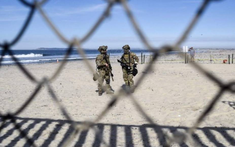 US police agents stand guard near the U.S.-Mexico border fence as seen from Playas de Tijuana, Mexico, on November 15, 2018. - US Defence Secretary Jim Mattis said Tuesday he will visit the US-Mexico border, where thousands of active-duty soldiers have been deployed to help border police prepare for the arrival of a 'caravan' of migrants. (Photo by ALFREDO ESTRELLA / AFP)