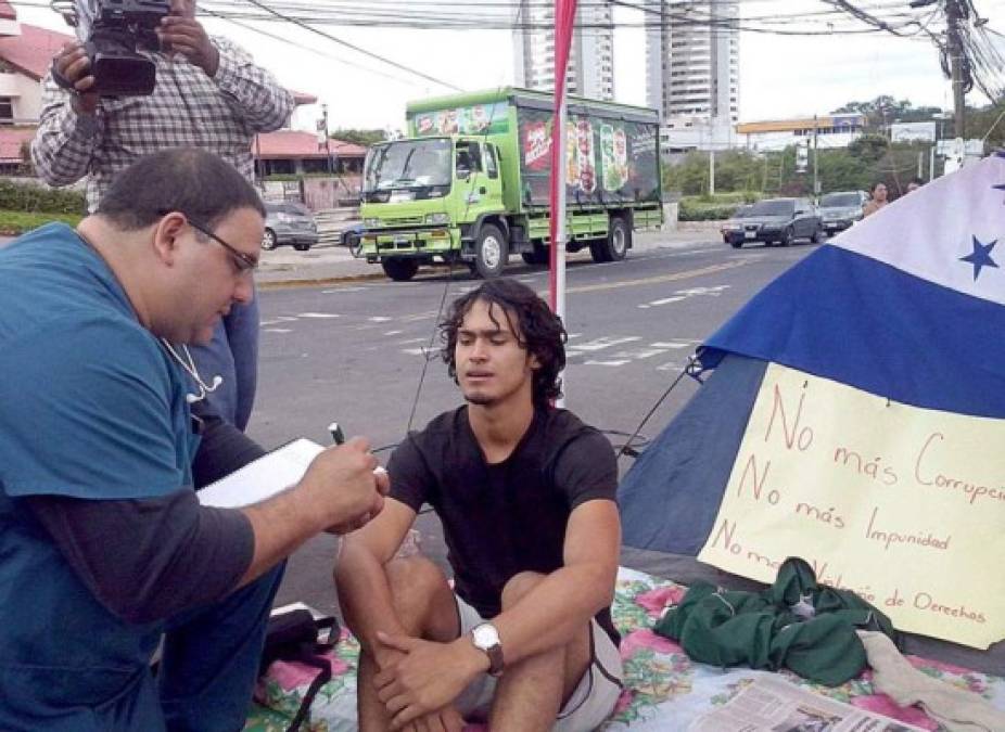 Un joven indigando, que permanece en huelga, es entrevistado por un reportero.