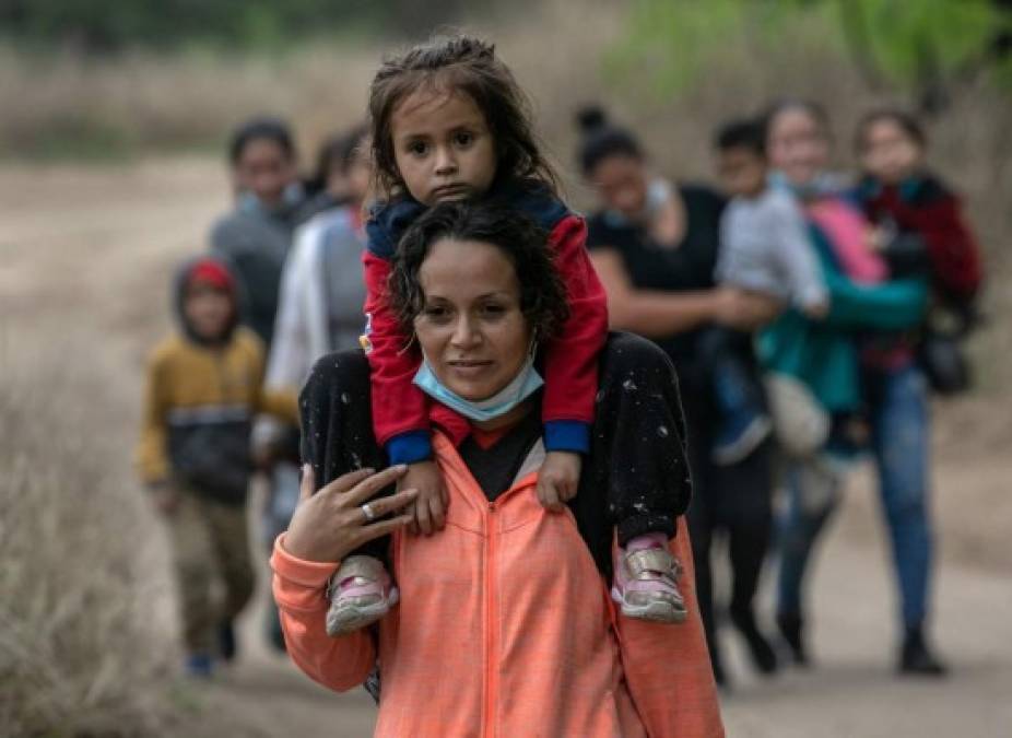 MISSION, TEXAS - MARCH 23: Asylum seekers from Honduras walk towards a U.S. Border Patrol checkpoint after crossing the Rio Grande from Mexico on March 23, 2021 near Mission, Texas. A surge of migrant families and unaccompanied minors is overwhelming border detention facilities in south Texas' Rio Grande Valley. John Moore/Getty Images/AFP<br/><br/>== FOR NEWSPAPERS, INTERNET, TELCOS & TELEVISION USE ONLY ==<br/><br/>