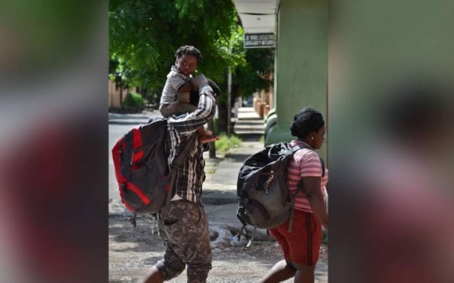 Una familia de migrantes haitianos camina hacia la oficina de migraciones en Choluteca, Honduras, el pasado 16 de noviembre de 2019, después de pasar por un cruce ciego entre Nicaragua y Honduras en su camino a los Estados Unidos.