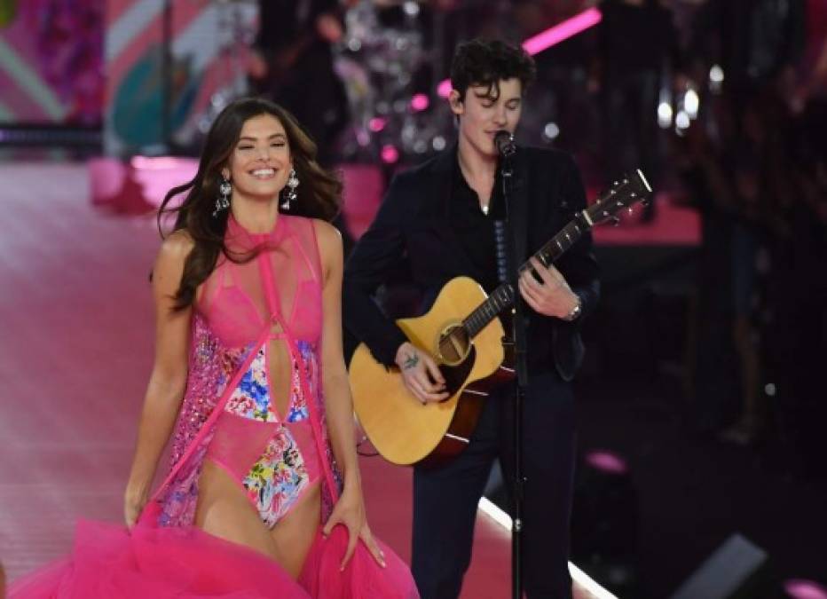 La modelo estadounidense Sofie Rovenstine pasa por delante de Shawn Mendes mientras se presenta en la pasarela del desfile de modas de Victoria's Secret de 2018 el 8 de noviembre de 2018 en Pier 94 en la ciudad de Nueva York