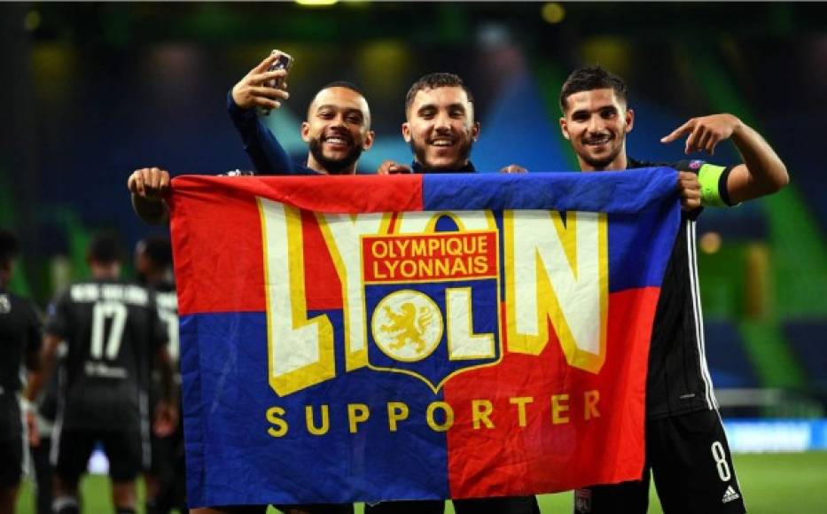 Los jugadores del Lyon celebrando con una bandera del equipo.