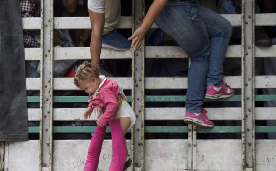 Quienes están en mejores condiciones trepan por sus propios medios por las estacas de los camiones solidarios que prometen ahorrarles kilómetros de caminata. Los más pequeños son ayudados a meterse dentro de los vehículos.