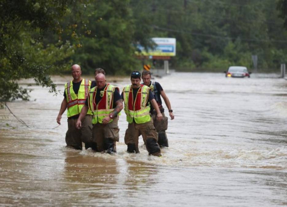 PACE, FL - SEPTEMBER 16: Members of the Pace Fire Rescue department wade through a flooded road after Hurricane Sally passed through the area on September 16, 2020 in Pensacola, Florida. The fire rescue personnel were checking on a vehicle that they thought was possibly occupied, but the occupants had already gotten out. The storm brought heavy rain, high winds and a dangerous storm surge to the area. Joe Raedle/Getty Images/AFP<br/><br/>== FOR NEWSPAPERS, INTERNET, TELCOS & TELEVISION USE ONLY ==<br/><br/>