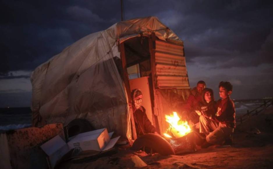Gaza. <br/>El calor de la familia. Una familia pobre se calienta en torno a un fuego en una choza a lo largo de la playa en Gaza.