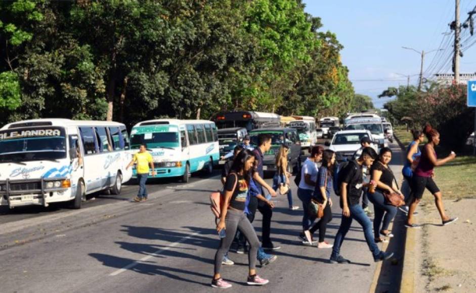 En el bulevar del este cientos de trabajadores de una maquila que van hacia La Lima cruzan la carretera para tomar el bus. Ruegan por puente peatonal.