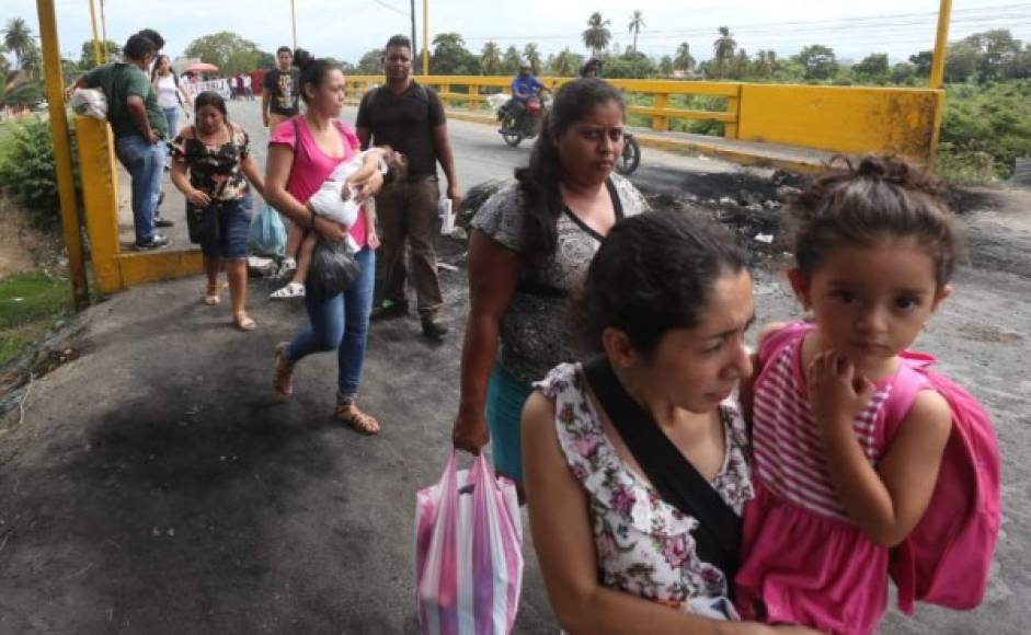 Cruzaron el puente de punta a punta, varias madres con sus hijos en brazos se vieron obligadas a caminar grandes distancias debido a la protesta que maestros realizaron en el sector de Quebrada Seca, El Progreso. Fotos Moisés Valenzuela/LA PRENSA.