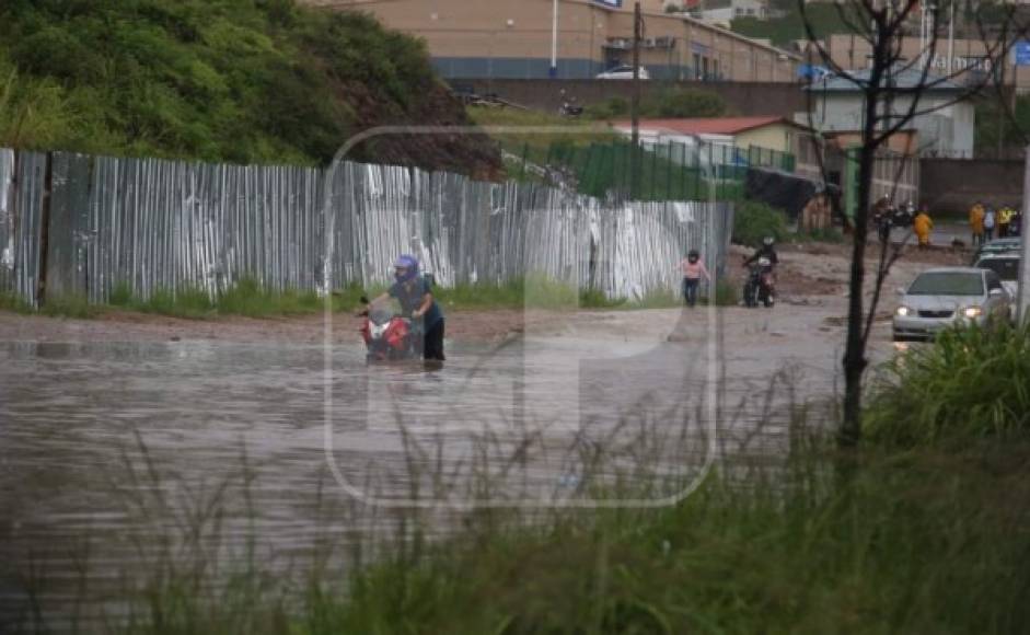 Otro motociclista que tuvo que empujar su vehículo. El agua llegaba a sus rodillas.