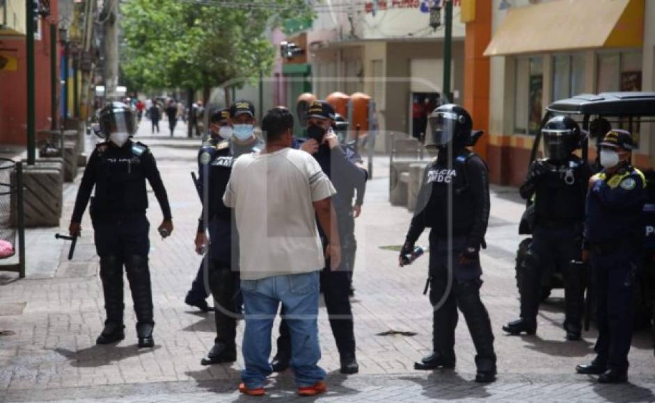 Un vendedor trata de dialogar con los policías municipales para que los dejen vender sus productos.