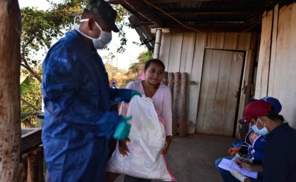 Militares hondureños en camiones verde olivo recorrieron este miércoles barrios pobres de la capital para distribuir comida a personas en aislamiento social por el nuevo coronavirus, que deja 36 contagiados en el país.<br/>