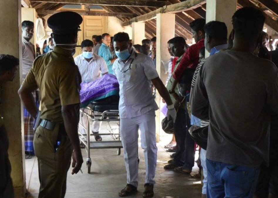 Sri Lankan hospital workers transport a body on a trolley at a hospital morgue following an explosion at a church in Batticaloa in eastern Sri Lanka on April 21, 2019. - A series of eight devastating bomb blasts ripped through high-end hotels and churches holding Easter services in Sri Lanka on April 21, killing nearly 160 people, including dozens of foreigners. (Photo by LAKRUWAN WANNIARACHCHI / AFP)