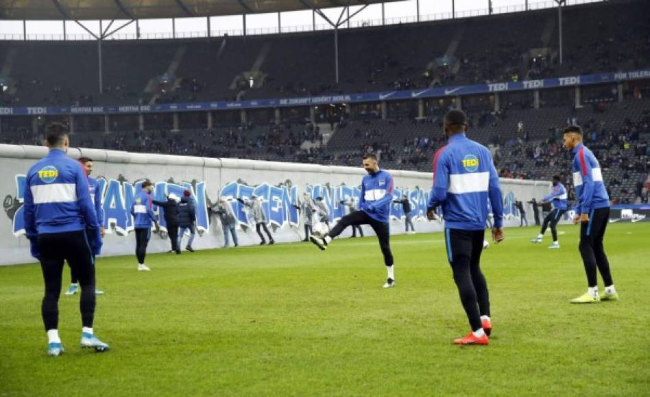 A cada uno de los lados del Muro de Berlín, calentaban los dos equipos.