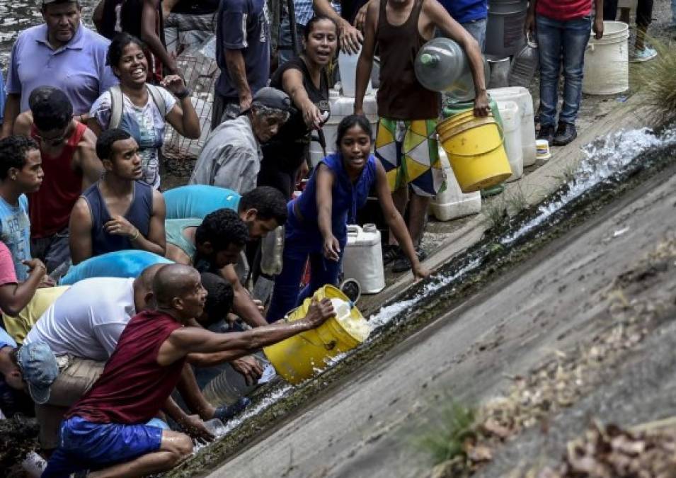 Desesperados por la escasez de agua, alimentos y medicinas, cientos de venezolanos se lanzaron este lunes a recoger agua del contaminado río Guaire debido a la imposibilidad de recibir el vital líquido en sus hogares por causa del apagón que afecta al país desde el pasado jueves.