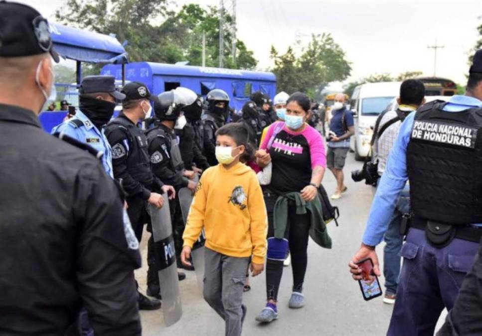 En la larga marcha, la mayoría lleva mochilas, mascarillas por la pandemia y banderas de Honduras. <br/>