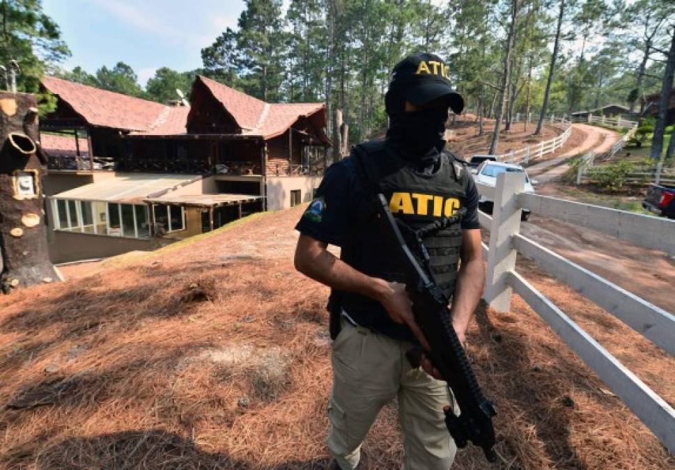 Un agente de la Atic resguarda la casa de campo de la ex primera dama Rosa Bonilla de Lobo. AFP