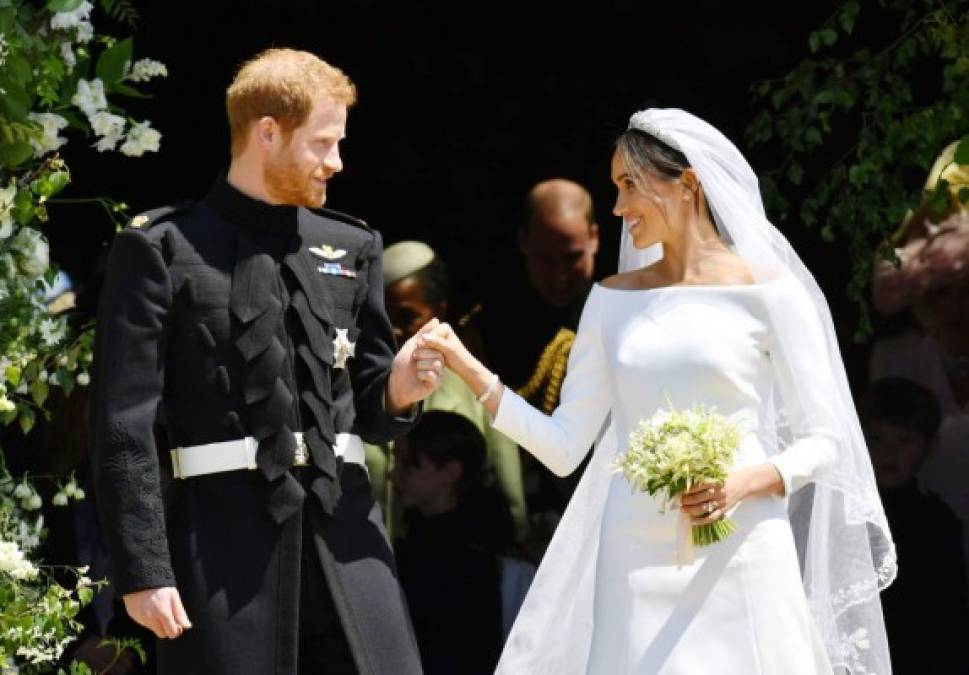 Britain's Prince Harry, Duke of Sussex and his wife Meghan, Duchess of Sussex emerge from the West Door of St George's Chapel, Windsor Castle, in Windsor, on May 19, 2018 after their wedding ceremony. / AFP PHOTO / POOL / Ben Birchall