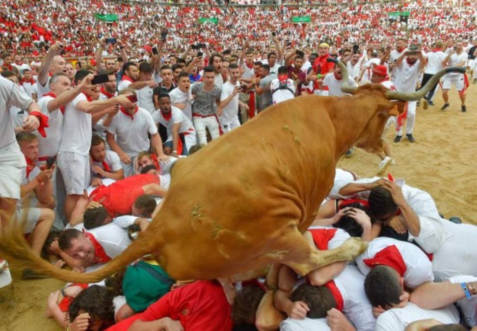 Los corredores, ataviados de camisa y pantalón blancos y con un pañuelo rojo al cuello, se encomiendan a San Fermín antes de ser perseguidos por los gigantescos toros.