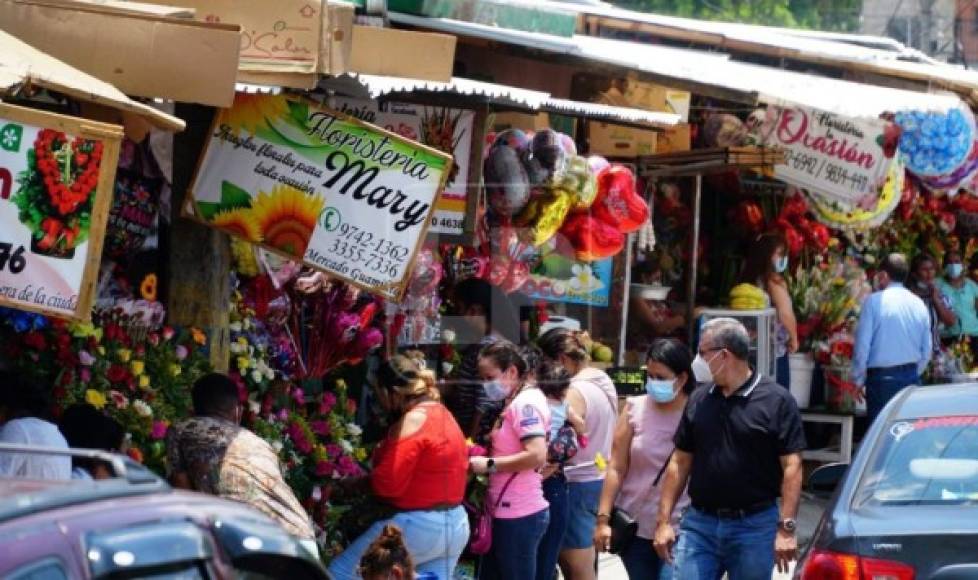 A inmediaciones del tradicional mercado Guamilito se arropan, como cada mayo, los pequeños comercios con adornos florales y detalles. La confluencia de colores otorga al lugar animosidad e invita a sampedranos a buscar detalles para sus madres. Fotografía: José Cantarero