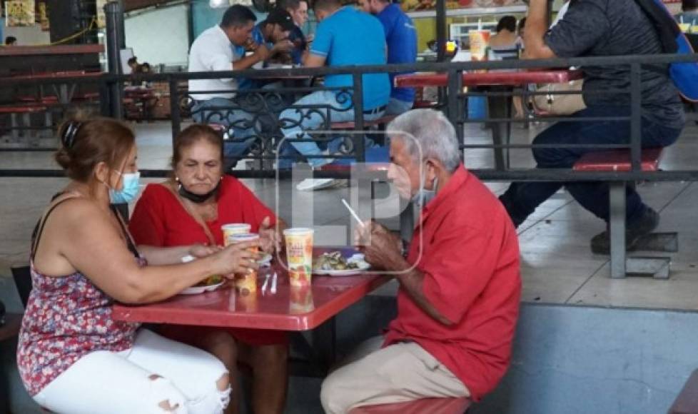 Hija comparte un tradicional almuerzo junto a sus padres, en la plaza típica 'Coracts', en la tercera avenida de San Pedro Sula. Fotografía: José Cantarero