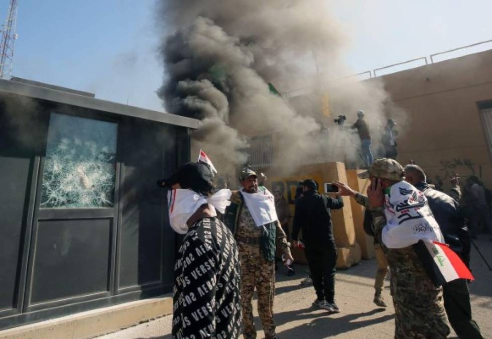 Members of the Iraqi pro-Iranian Hashed al-Shaabi group and protesters set ablaze a sentry box in front of the US embassy building in the capital Baghdad to protest against the weekend's air strikes by US planes on several bases belonging to the Hezbollah brigades near Al-Qaim, an Iraqi district bordering Syria, on December 31, 2019. - Several thousand Iraqi protesters attacked the US embassy in Baghdad on today, breaching its outer wall and chanting 'Death to America!' in anger over weekend air strikes that killed pro-Iran fighters. (Photo by Ahmad AL-RUBAYE / AFP)