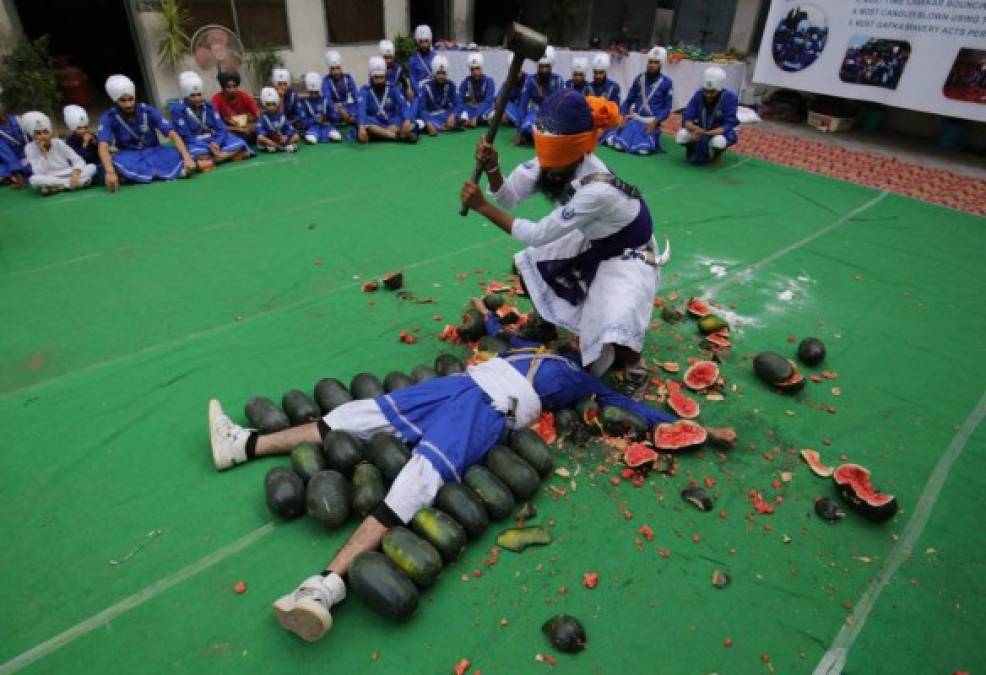 INDIA. Golpe a las sandías con los ojos cerrados . Un religioso sij, practicante de la Gatka (arte marcial milenario), intenta golpear con los ojos cerrados las sandías que rodean a otro sij, busca un nuevo récord mundial.