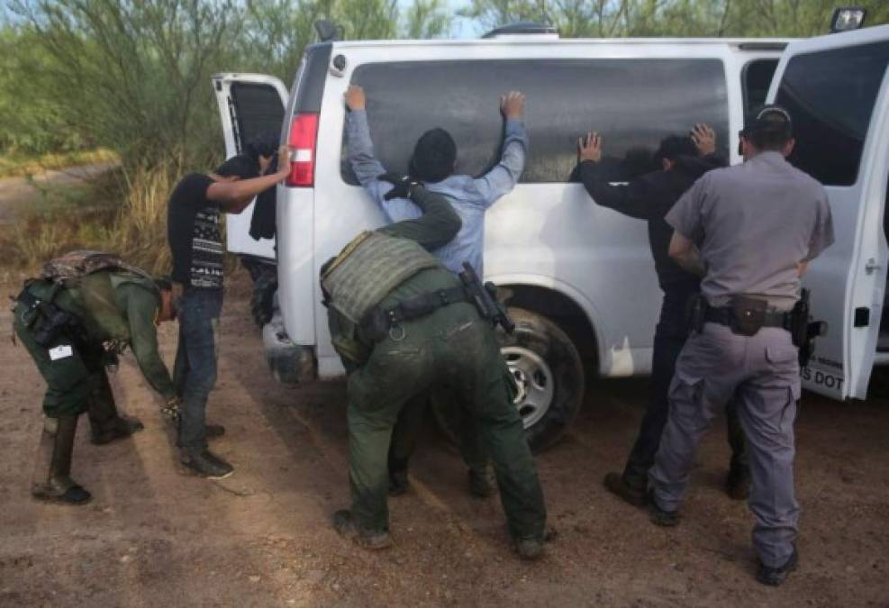 Agentes estadounidenses registran a varios indocumentados detenidos en la frontera sur de ese país.