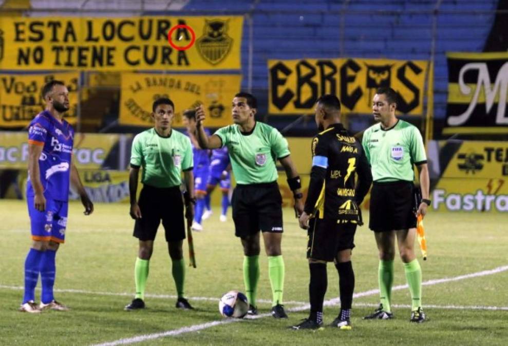 El árbitro Jefferson Escobar lanzando la moneda al aire para definir el lado de cancha previo al juego Real España-UPN.