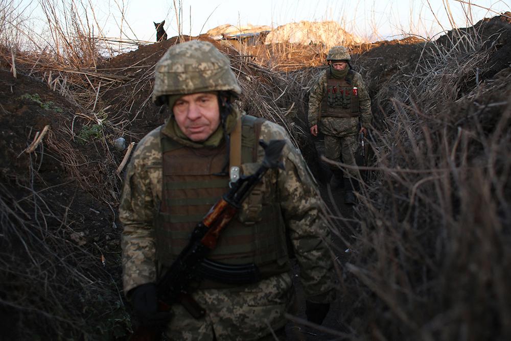 Militares de las Fuerzas Militares de Ucrania caminan a lo largo de tramos en su posición en la línea del frente con los separatistas respaldados por Rusia, cerca de la aldea de Novognativka, región de Donetsk, el 21 de febrero de 2022.Anatolii.