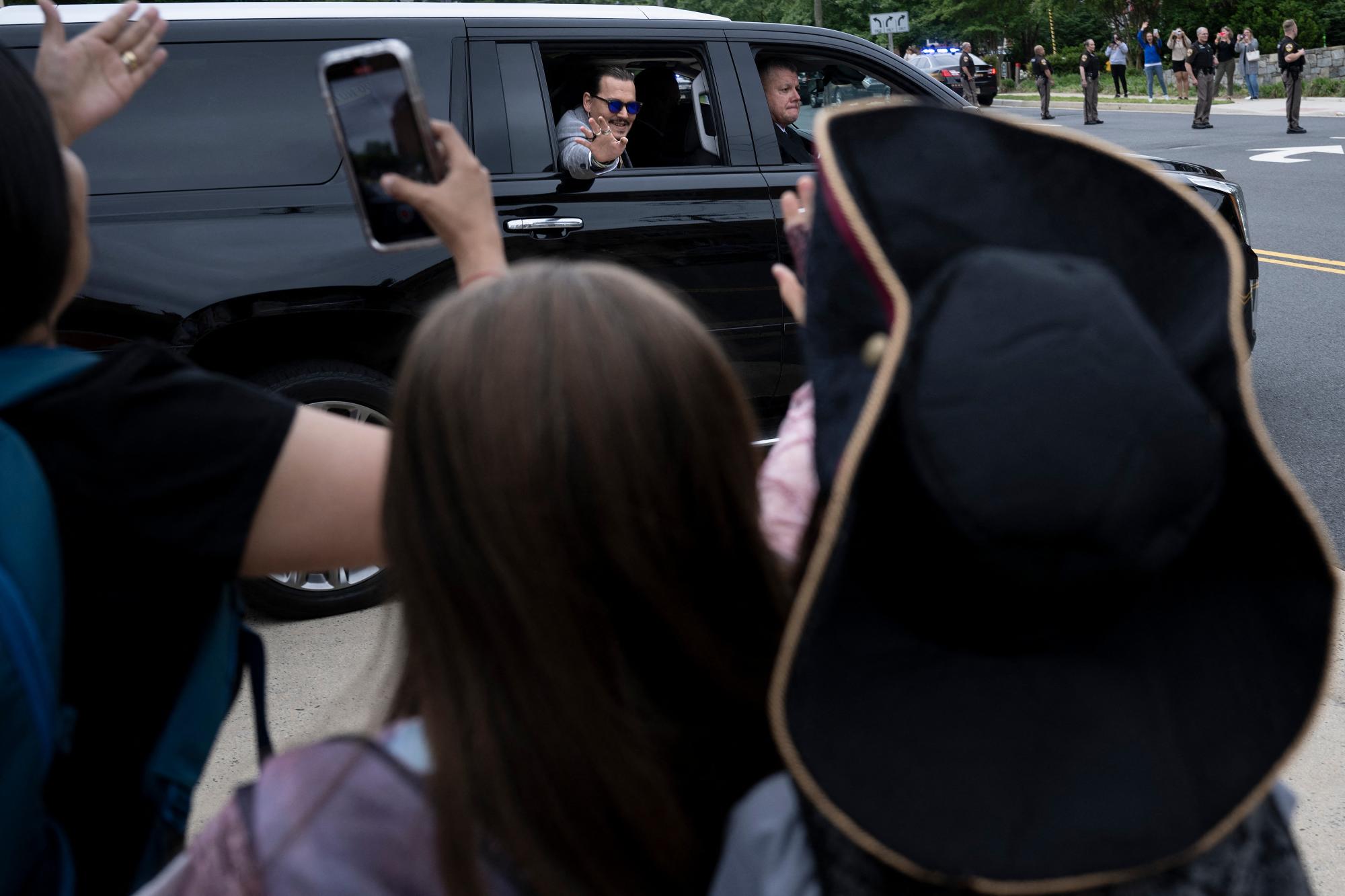 Johnny Depp saluda a sus fans afuera de la corte en Fairfax, Virginia.