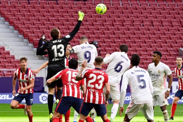 Atletico Madrid's Slovenian goalkeeper Jan Oblak (L) jumps for the ball during the Spanish league football match Club Atletico de Madrid against Real Madrid CF at the Wanda Metropolitano stadium in Madrid on March 7, 2021. (Photo by JAVIER SORIANO / AFP)