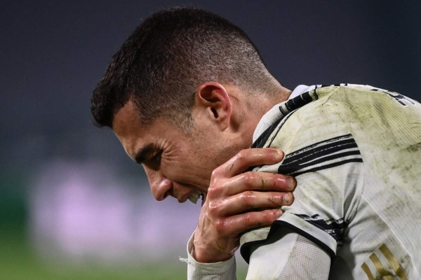 Juventus' Portuguese forward Cristiano Ronaldo reacts in pain after being tackled during the UEFA Champions League round of 16 second leg football match between Juventus Turin and FC Porto on March 9, 2021 at the Juventus stadium in Turin. (Photo by Marco BERTORELLO / AFP)