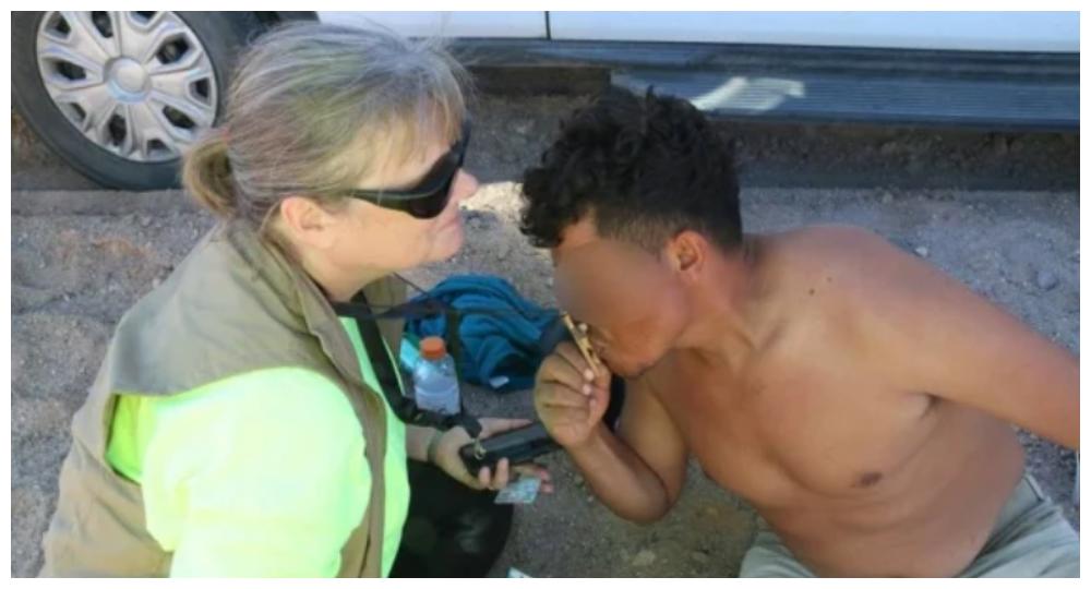 El hondureño besa el crucifijo de la voluntaria.